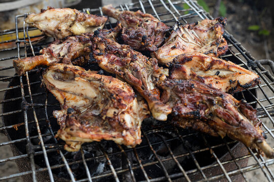 Grilled chicken Leg on the grill. Tasty chicken legs and wings on the grill with fire flames. Outdoor Barbecue Grill. Delicious chicken  barbecue on hot grill. Image about delicious food.