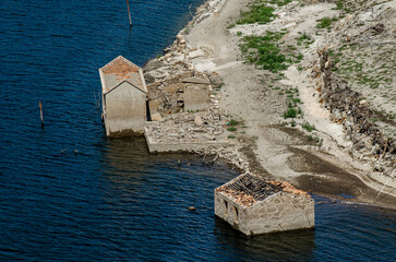 ruins of houses of an old flooded village, emerging from the drought