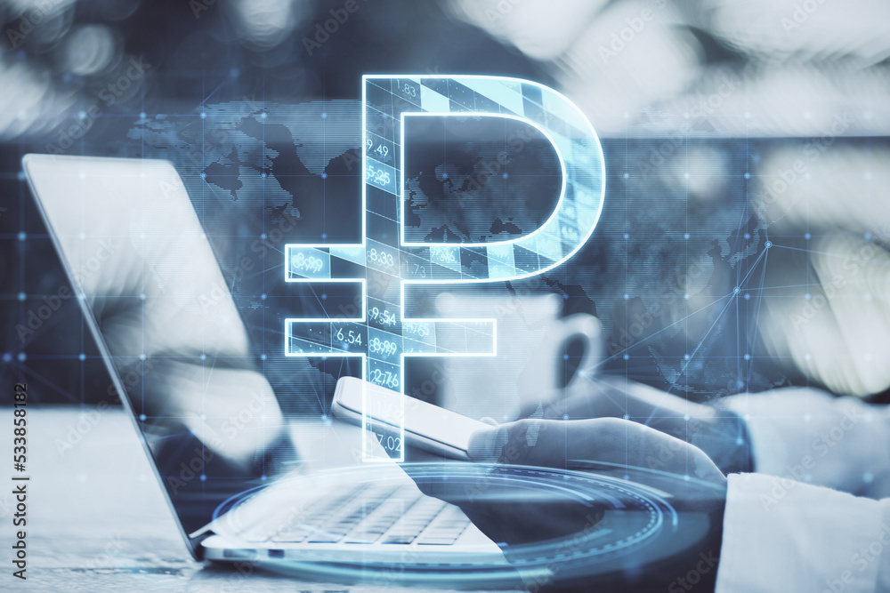 Poster close up of businessman hands using laptop and smartphone with glowing ruble and map hologram on blu