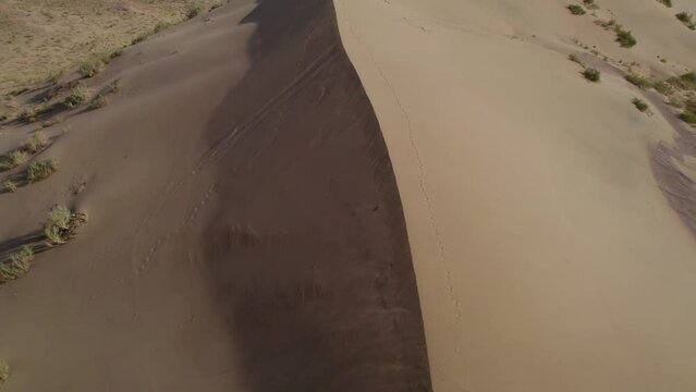 Desert breeze blows sand off Singing Dunes, Aerial Altyn Emel Almaty Kazakhstan