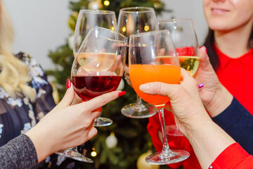Holidays,celebration and people concept - happy friends having christmas dinner at home drinking alcoholic red wine and champagne.Closeup.