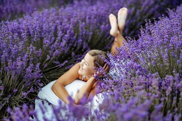 A middle-aged woman lies in a lavender field and enjoys aromatherapy. Aromatherapy concept, lavender oil, photo session in lavender