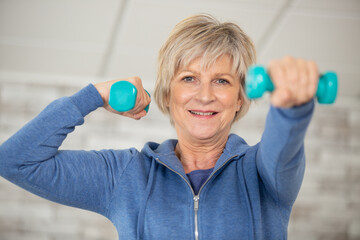 cheerful senior lady exercising with weights