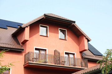 Fototapeta na wymiar View of house with balconies and solar panels on roof