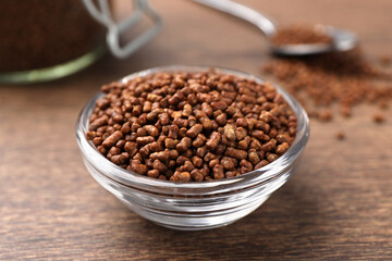 Buckwheat tea granules in glass bowl on wooden table, closeup
