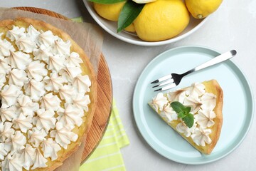 Cut delicious lemon meringue pie served on light table, flat lay