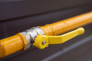Gas pipe in the house. Yellow gas pipe. Gas pipe and valve. Home gas valve.