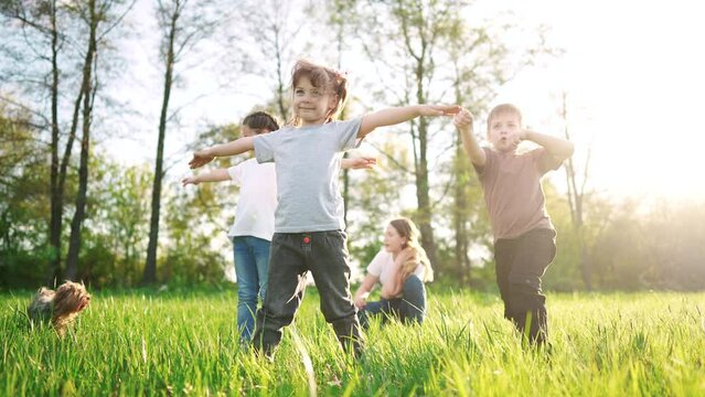 group of children in the park portrait. happy family baby kid dream concept. kindergarten. children play on green grass sun in forest park in summer sunlight