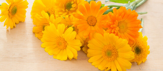 Bunch of  fresh yellow flowers on a wooden board. Nature background.