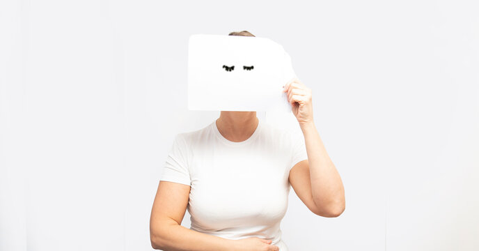 bella ragazza su sfondo bianco che regge un foglio  dove sono disegnate delle ciglia per simboleggiare i suoi occhi chiusi