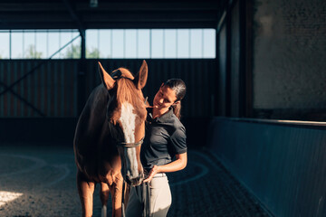 horsewoman riding instructor bonding with horse in horse farm