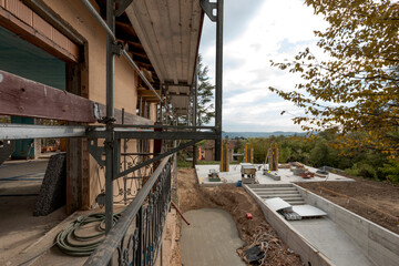 Exterior old villa under construction. The garden has disappeared and the pool is already being excavated