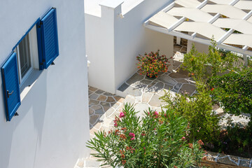 A white washed house with blue window shutters and a terrace  in Ios Greece