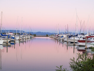 Boats moored in marina at sunset