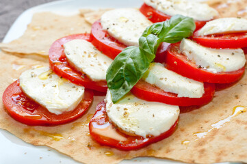 Caprese Salad With Buffalo Mozzarella Cherry Tomatoes And Basil on Carasau Bread