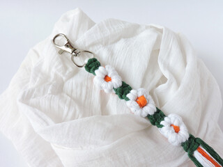 Macrame keychain made of cotton thread. Handcrafted work. Decoration Artworks. Handicrafts. Macrame art for gift. Keychain isolated on a white background. Handmade souvenir. 