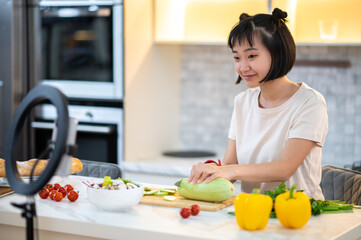 Female cook recording a cookery vlog for her followers