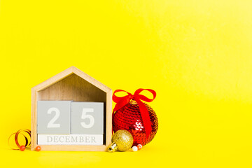 25 december. Christmas composition on colored background with a wooden calendar, with a gift box,...