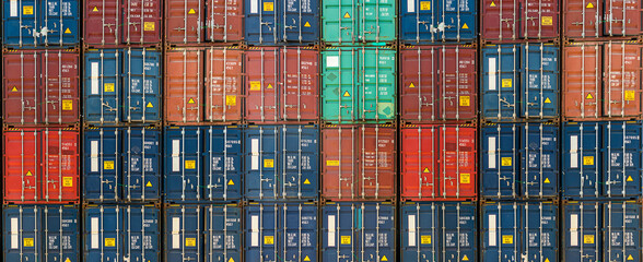 Fototapeta Stack of containers in a harbor. Shipping containers stacked on cargo ship. Background of Stack of Containers at a Port. obraz