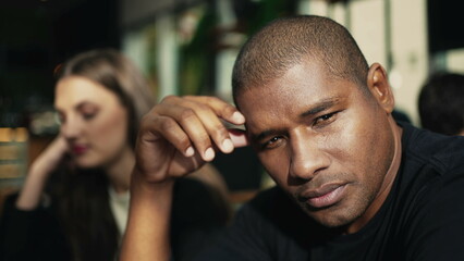 Contemplative African American male sitting at coffee shop pondering about life. A meditative black man