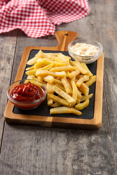 Fried potatoes with ketchup and Mayonnaise on wooden table