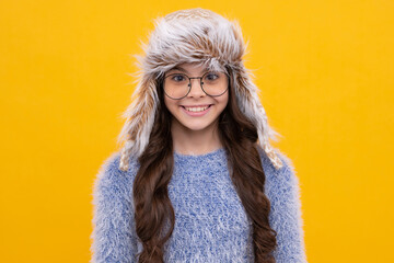 Fashion happy young woman in knitted hat and sweater having fun over colorful blue background....