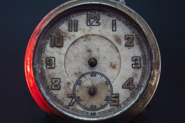 Antique silver broken pocket watch isolated on a black background, top view, The surface of the dial is peeling and cracked. Without arrows. Concept of lost time. Close up.
