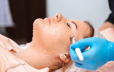 The girl at the beautician makes spa treatments, massage, facial cleansing and a mask for the skin....