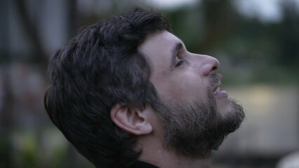 Obraz premium Hopeful man closing eyes in meditation. Contemplative person in 30s feeling peace in contemplation