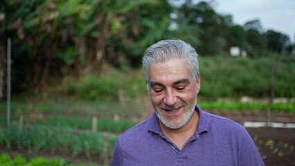 Happy older man walking forward in farm. Senior person portrait face at farmland