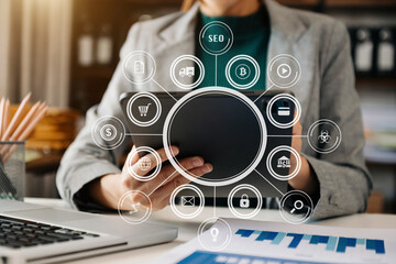 Designer woman using smart phone for mobile payments online shopping sitting on table,virtual icons .