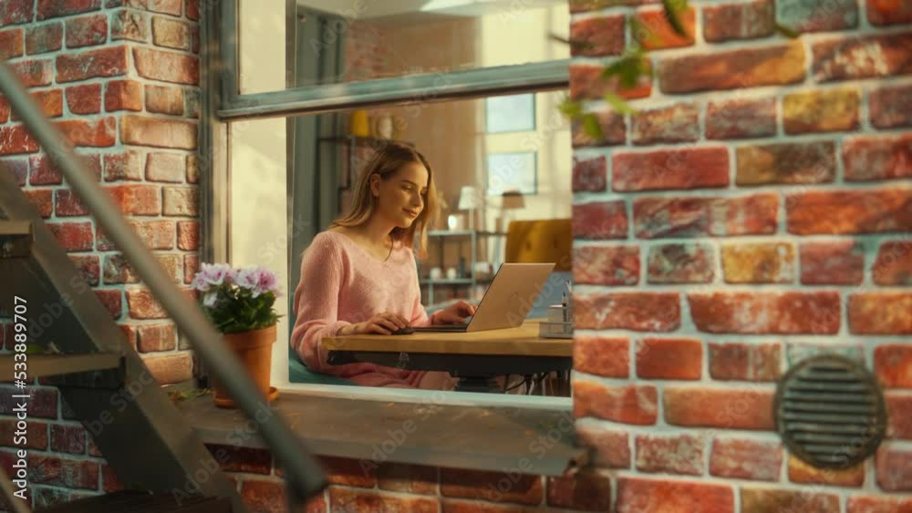 Aufkleber portrait of a young woman working on laptop computer while sitting at home in a multi-storey brick h