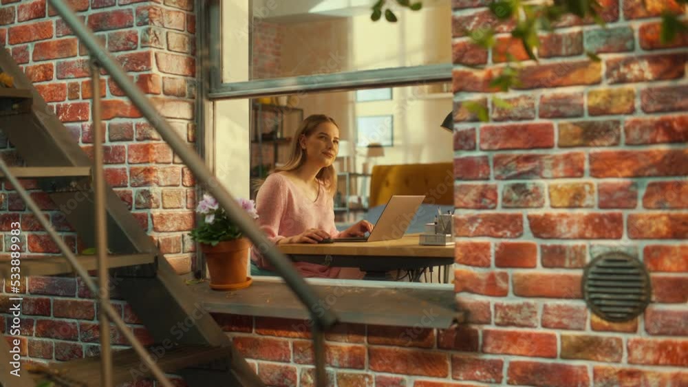Poster Portrait of a Female Using Laptop Computer while Sitting Behind a Table in Her Stylish Living Room. Creative Manager Thinking, Brainstorming Different Business Ideas while Working Remotely from Home.