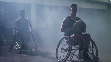Disabled basketball athletes in wheelchairs with dramatic lighting indoors
