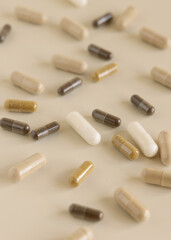 Mix of medical capsules on light beige close up. Taking dietary supplements