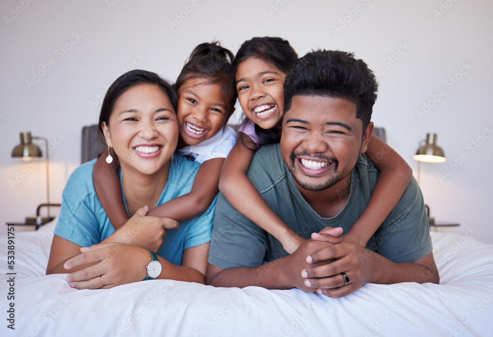 Sticker Portrait of a happy Asian family on the bed with a smile on their face. Multicultural Indian family in their bedroom smiling, laughing and having fun. Loving mom, dad and kids bond together at home