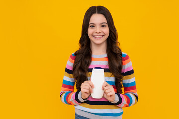 Teenager child girl with bottle shampoo conditioners or shower gel. Kids hair care. Hair cosmetic product, shampoo bottle. Happy teenager, positive and smiling emotions of teen girl.