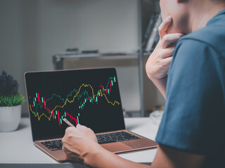 Business trader investor analyst for  financial instruments with various type of indicators combine with gold and account book and money, trading data index chart graph and laptop screen.