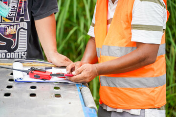 An engineer is using a cell phone to check prices and work meetings with workers at the...