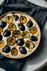 making plum cake. plum cake before putting in the oven. plum halves in raw dough top view
