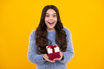 Teenager child in winter wear holding gift boxes celebrating happy New Year or Christmas. Winter kids holiday. Amazed teenager. Excited teen girl.