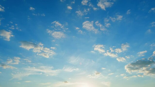 Beautiful blue sky with clouds background. Natural sunset white and yellow clouds floating on blue sky. Time lapse.