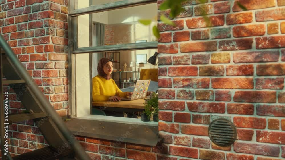 Poster young muslim female using laptop at home. doing remote work during the day. beautiful girl in a hija