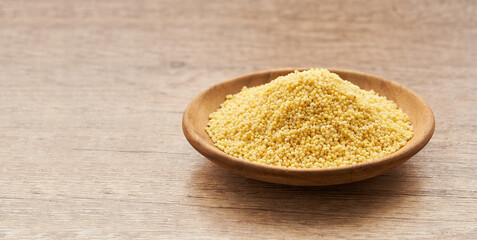 pile of sorghum or sorghum grain, millet grain or millet seed in wood plate on wooden table background                                                                                               