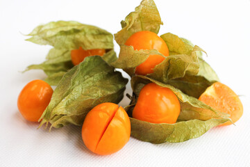 Close-up photo of the berries of the physalis plant. Bright orange fruits on a white background.