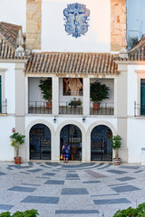 person praying in front of exvotos in a church in Olhao, Algarve, Portugal