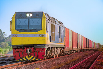 Obraz premium Container-freight train by diesel locomotive on the railway.