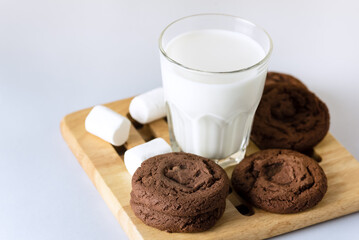 Glass of milk and Chocolate Cookies with Marshmallow Concept for a Tasty Snack Sweet Dessert Blue Background