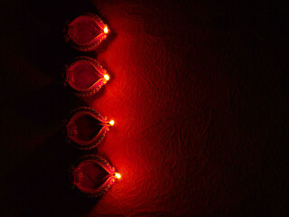 Oil lamps (Clay diya) lit on colorful rangoli during diwali celebration.Greeting Card Design Indian...