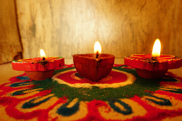 Oil lamps (Clay diya) lit on colorful rangoli during diwali celebration.Greeting Card Design Indian Hindu Light Festival called Diwali.